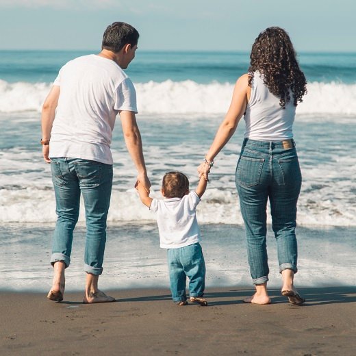 happy-family-with-baby-walking-beach-looking-sea